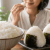 大粒の白ご飯と海苔を巻いたおにぎりを楽しむ新之助の食事イメージ