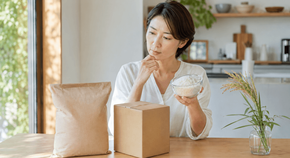 雪若丸の新米予約を検討する女性と米袋や配送箱