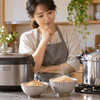 玄米を炊く炊飯器と圧力鍋を比較する女性