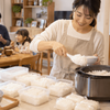 一升炊き炊飯器で大家族の食事と冷凍用ご飯をまとめて準備する女性