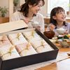 小分けされたお米の箱入りギフトと白ご飯を囲んで食事を楽しむ日本人家族