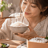 炊きたての白ご飯とお弁当のご飯を楽しむ日本人女性